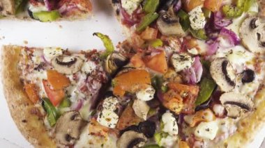 Bir daire üst görünümünde bir karton kutu içinde bitmiş pizza döner