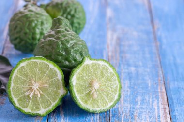 Kesit bergamot veya bergamot dilim. Bergamot ahşap masa arka plan üzerine kapatın. meyve suyu ile saç şampuan veya saç kremi tedavi için de Tayland mutfağı için popüler madde. Güney Afrika'da bir kabile kireç