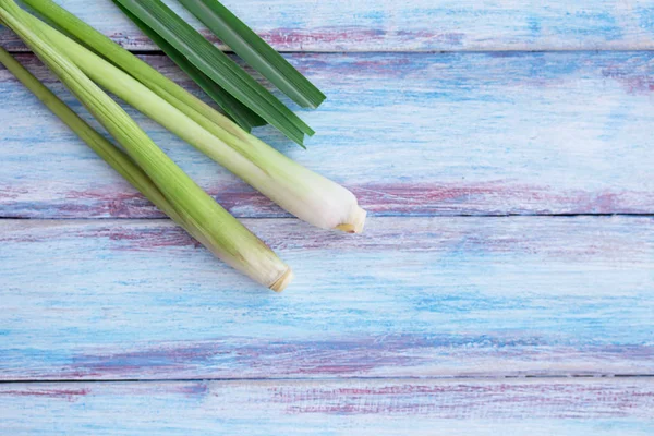 Close up fresh organic lemongrass no chemicals on wooden table background.Fresh stems of lemongrass on a wooden surface. Spa and aromatherapy concept.