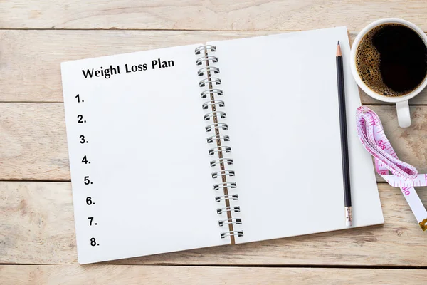Weight loss program written on book with black listing, planning conceptual.Top view with copy space (selective focus). Office desk table concept with copy space for any design.