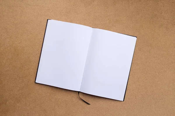茶色の木製のテーブルの背景に空白のメモ帳またはノートブック. — ストック写真