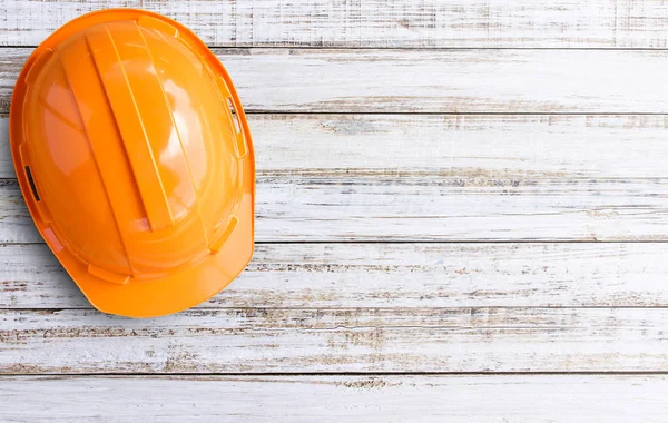 Cascos de seguridad naranja vista superior sobre fondo de mesa de madera blanca . — Foto de Stock