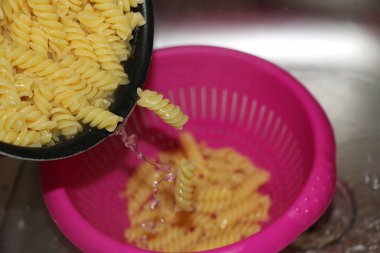 taze yemek noodles bir pembe plastik elek düşüyor