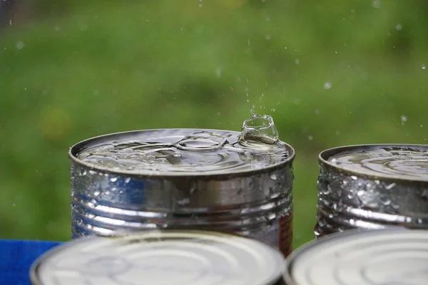 rain is splashing on the top of a can outdoor