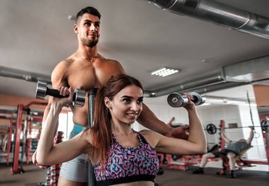 profesyonel bir eğitmen ile halter egzersiz uygun bir kız destekleyen