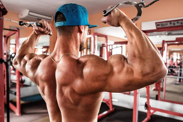 Bodybuilder Med Muskuløs Ryg Blå Hætte Gør Øvelser Biceps Gymnastiksalen - Stock-foto