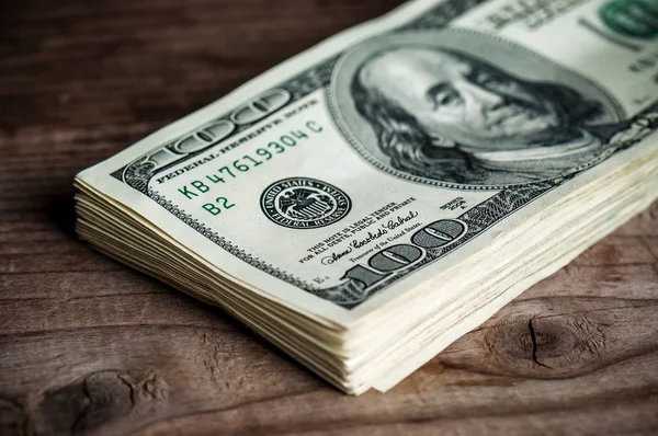 ahşap arka plan üzerinde yüz dolar yığını