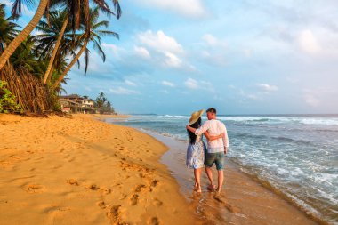 Genç çift tropik plajda balayına çıkıyor.