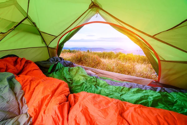 sleeping bag inside of a tent looking out with view through the back door