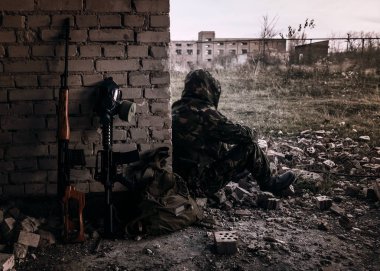 Keskin nişancı tüfeği, gaz maskesi ve asker. Koyu tonlu bir fotoğraf. Sapık teması. Nükleer kıyamet sonrası hayatta kalanlar.