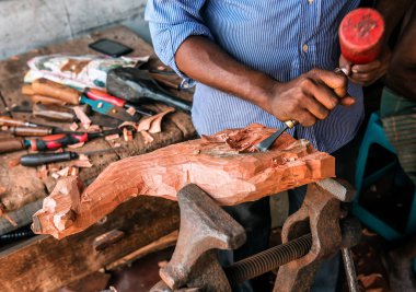 Usta atölyede tahta figürler yapıyor.