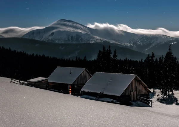 在月光下 两个冬山的旧木屋 — 图库照片