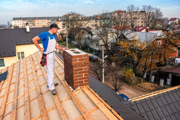 Maestro de techo cerca de la chimenea —  Fotos de Stock