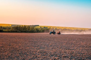 Traktör tarlayı eker.