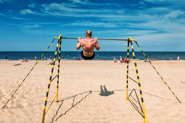 Sportif faisant des exercices sur le bar de la plage — Photo