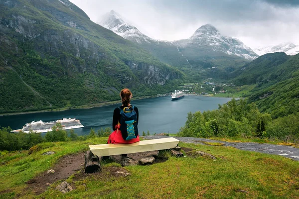 Ta dívka sedí na lavičce pod fjordem. Norsko — Stock fotografie