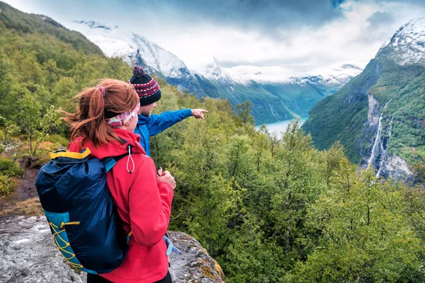 Turistický průvodce ukazuje dívčí vodopád v horách Norska — Stock fotografie