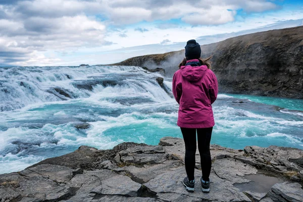 Das Mädchen blickt auf den Wasserfall Gullfoss in Island — Stockfoto