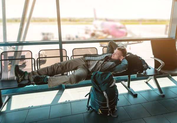 Joven duerme en la terminal del aeropuerto — Foto de Stock
