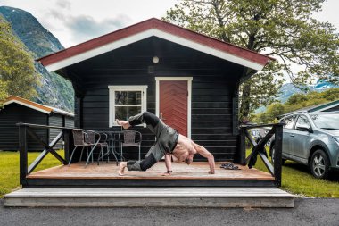 Çıplak gövdeli adam Norveçli kampında sabah egzersizi yapıyor.