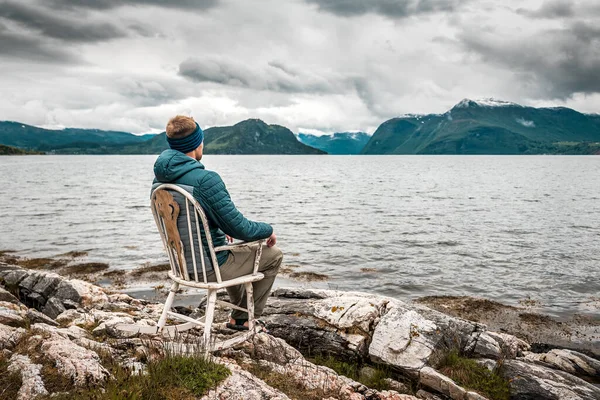 Norveç Fiyordun Kıyısında Eski Bir Sallanan Sandalyede Oturan Bir Adam — Stok fotoğraf