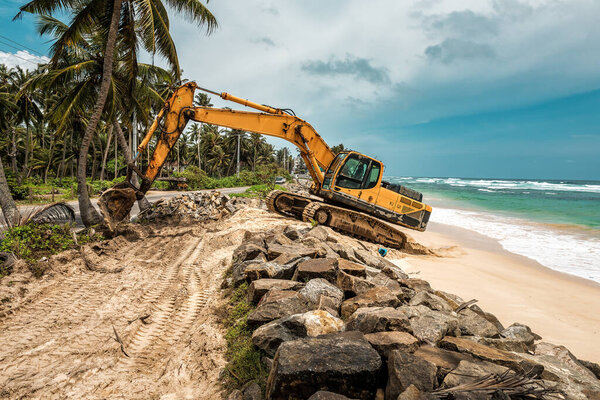 the excavator strengthens the tropical shore of the ocean