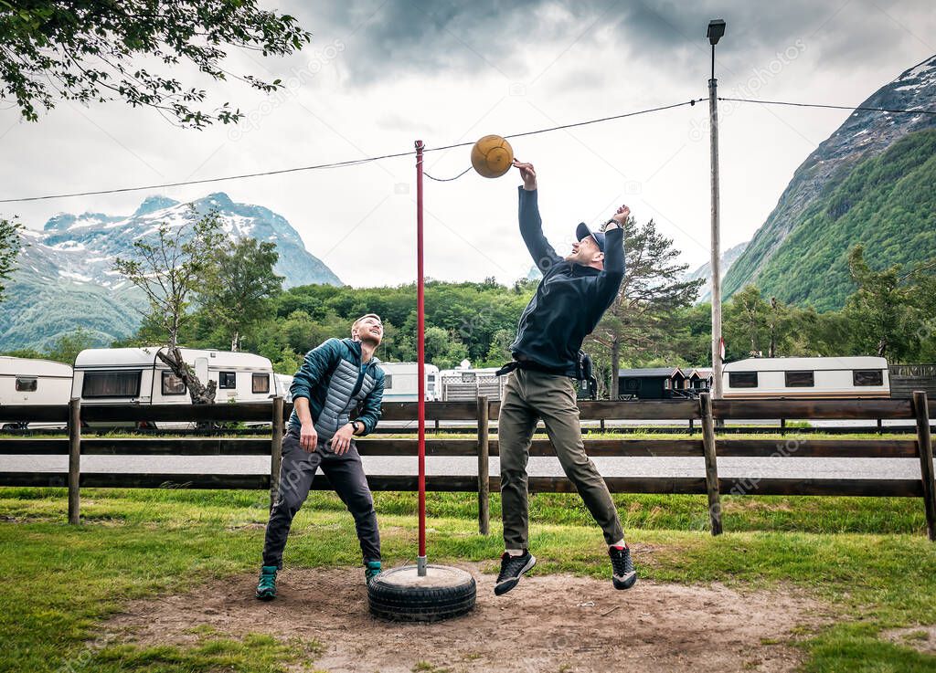 two friends are playing tetherball game in Norwegian camping