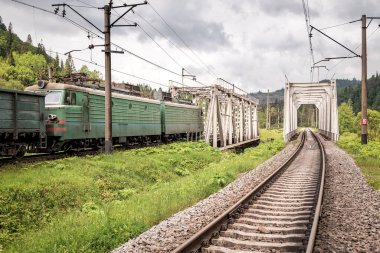 Kargo treni ve demiryolu köprüsü. Sanayi manzarası