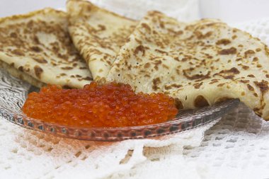 Bir cam tabakta kırmızı havyar ile geleneksel Rus krep