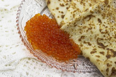 Bir cam tabakta kırmızı havyar ile geleneksel Rus krep