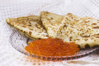 Bir cam tabakta kırmızı havyar ile geleneksel Rus krep