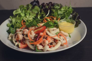 Deniz ürünleri salatası, sebze salatası ile düzenlenmiş.