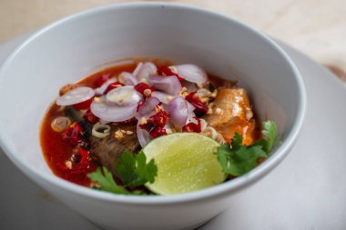 Beyaz bir fincanda domates soslu sardalya salatası.