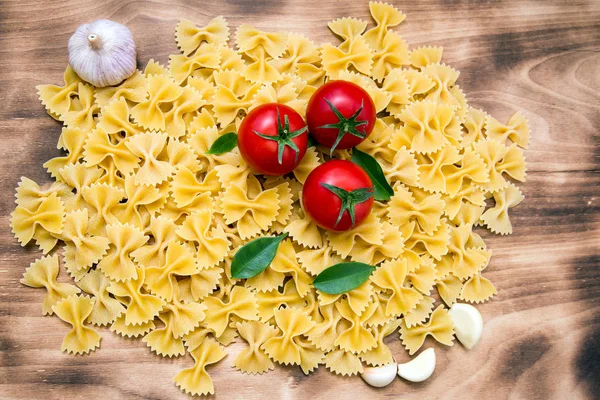 eski ve vintage ahşap masada otlar ile makarna Farfalle ve domates