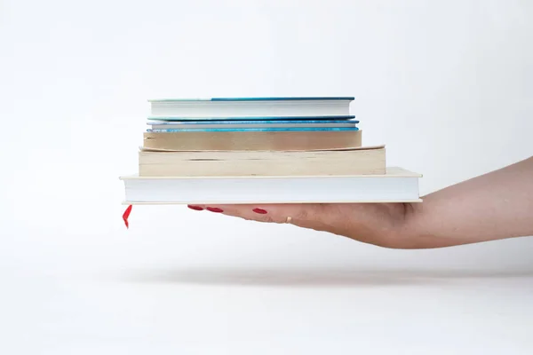 kırmızı manikür kitap beyaz arka plan bir yığın tutan kadın el