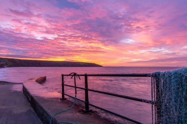 Bir muhteşem gündoğumu doğru Filey Brigg yüksek gelgit Balıkçı İskelesi, Filey, North Yorkshire, İngiltere arıyor