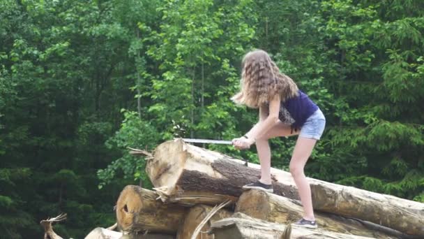 Meisje snijdt een boom door machete — Stockvideo