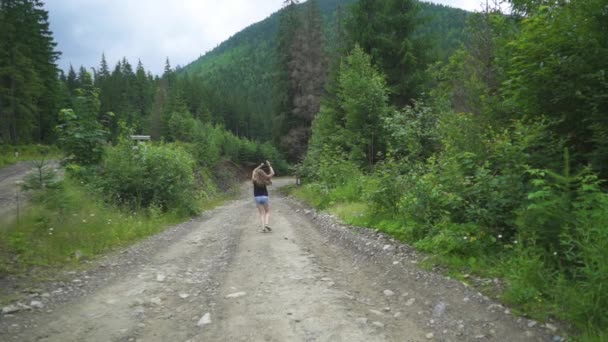 Una chica corre a través de un camino forestal — Vídeos de Stock