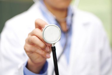 Doktor steteskop kullanarak hastayı kontrol ediyor. Hastane koğuşundaki bir yatağa uzanıyor. Sağlıklı, güçlü bir tıbbi konsept. 