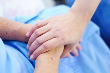 Dokunmadan eller Asya kıdemli veya yaşlı yaşlı kadın kadın hasta ile sevgi, bakım, yardım, teşvik ve hastane koğuşunda hemşirelik, empati: sağlıklı güçlü tıp kavramı 