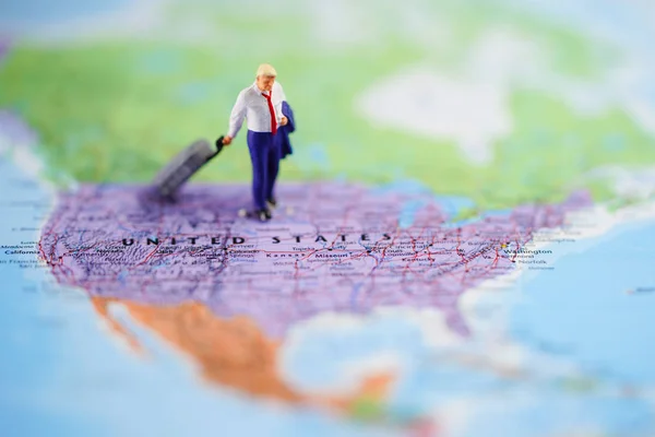 Miniature people: Smart business man discovery journey travel to work with good successful job and salary at amazing United State of America (USA) country in America continent of globe world map.