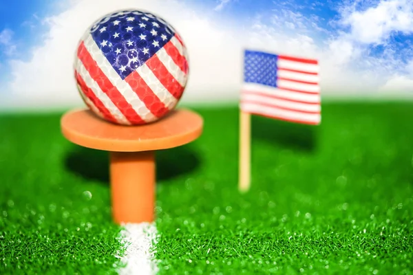 Golf ball with USA flag on green lawn or field : most popular sport in the world.