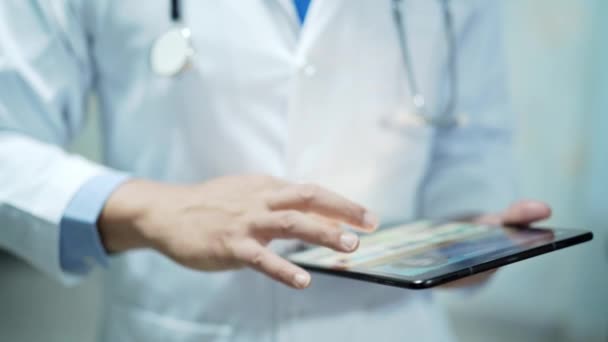 asiatischer Smart-Man-Arzt mit digitaler Tablet-Technologie zur Wissenssuche löst Behandlung von Patienten auf Krankenhausstation: gesundes starkes medizinisches Konzept.