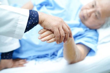 Holding dokunmadan eller Asya kıdemli veya yaşlı yaşlı kadın kadın hasta ile sevgi, bakım, yardım, teşvik ve hastane koğuşunda Hemşirelik, empati: sağlıklı güçlü tıp kavramı 