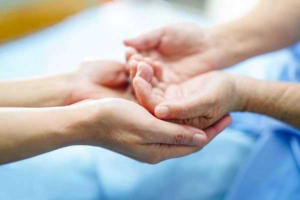Holding Touching hands Asian senior or elderly old lady woman patient with love, care, helping, encourage and empathy at nursing hospital ward : healthy strong medical concept