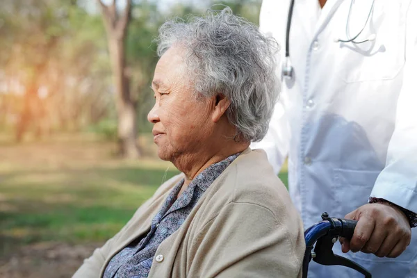 Doctor help and care Asian senior or elderly old lady woman patient sitting on wheelchair at nursing hospital ward : healthy strong medical concept