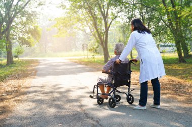 Doktor yardım ve bakım Asya yaşlı yaşlı yaşlı kadın hasta hemşirelik hastanesi koğuşunda tekerlekli sandalyede oturan: sağlıklı güçlü tıbbi kavram 