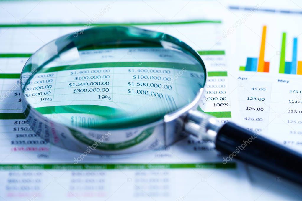 Magnifying glass on Spreadsheet table paper. Finance development, Banking Account, Statistics Investment Analytic research data economy, trading, Mobile office reporting Business company meeting concept.