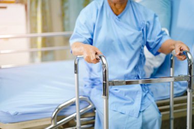 Asyalı yaşlı ya da yaşlı kadın hasta bakıcı hastanesinde Walker 'la birlikte yürüyor. Sağlıklı güçlü tıbbi konsept.