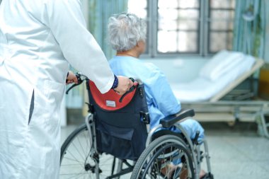 Doktor yardım ve bakım Asya yaşlı yaşlı yaşlı kadın hasta hemşirelik hastanesi koğuşunda tekerlekli sandalyede oturan: sağlıklı güçlü tıbbi kavram